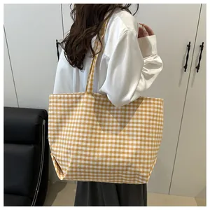 Detail of large canvas tote bag featuring yellow and white gingham pattern for summer daily use