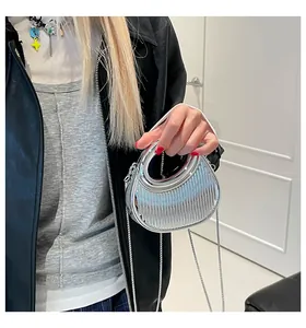 Détail du sac à main argenté métallisé avec plis verticaux et chaîne en métal