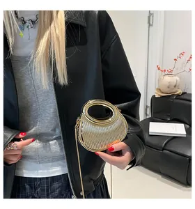 Vue détaillée du sac pochette doré en acrylique avec rayures verticales et chaîne