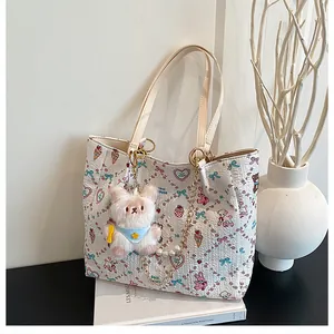 Detail of cartoon bear print tote bag with pearl chain and white plush bear charm