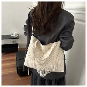 Dettaglio della borsa tote intrecciata crema con motivi vintage a V e lunghe nappe