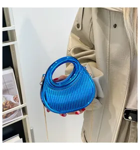 Détail du mini sac bleu métallisé avec texture verticale et chaîne dorée