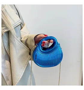 Détail de la pochette bleu électrique métallisé avec poignée ronde et texture lignée