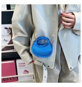 Gros plan d'une pochette en acrylique bleu vif avec plis verticaux et chaîne dorée
