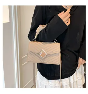 Close-up van beige gewatteerde crossbodytas met V-stiksel en geplooid handvat