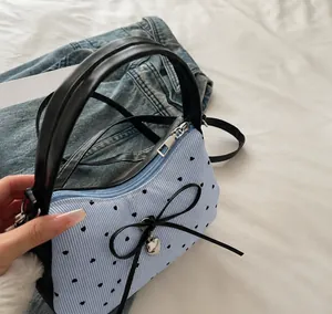 Detail of smooth metal zipper and blue striped fabric with heart prints and bow