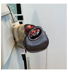 Détail du mini sac métallisé gris fusil avec texture plissée et chaîne dorée