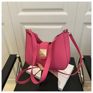 Détail du sac demi-lune rose fuchsia avec boucle métallique dorée et texture en cuir PU