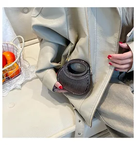 Détail du sac en acrylique marron à rayures verticales et chaîne dorée