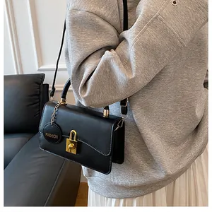 Dettaglio borsa vintage in pelle nera con fibbia dorata e targhetta fashion moda