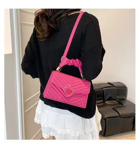 Detail van een fuchsia gewatteerde crossbodytas met gerimpeld handvat en gouden gesp