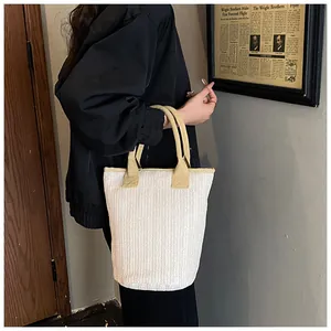 Detailed view of beige woven tote bag texture with light brown handle for commuting