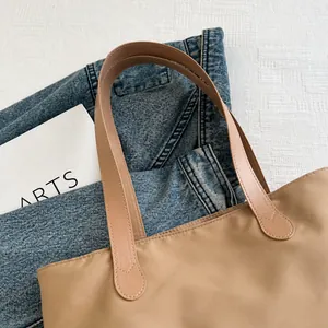 Gros plan des poignées beiges confortables avec coutures soignées et cuir PU durable