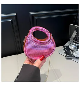 Détail du sac dumpling en acrylique rose avec poignée ronde et chaîne dorée