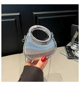 Détail d'un mini sac à main argenté avec rayures verticales et poignée ronde