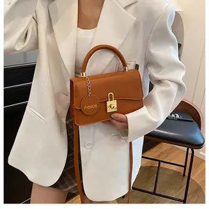 Dettaglio borsa a tracolla marrone retrò con fibbia dorata e targhetta in pelle alla moda