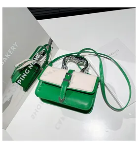 Detail of green and white color-block crossbody bag with silver liquid metal handle