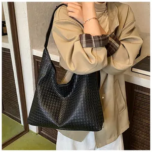 Close-up of black woven leather texture on a large hobo tote bag for women