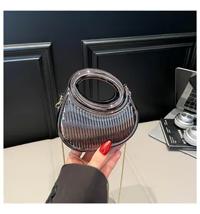 Vue détaillée d'un sac argenté en acrylique avec rayures verticales et anse ronde