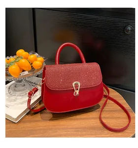 Vue détaillée du sac à main rouge à paillettes avec boucle dorée et texture brillante