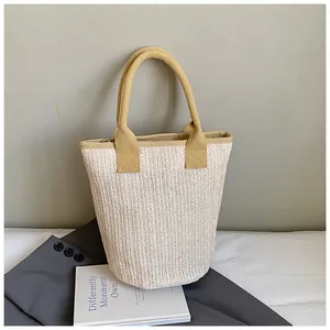 Detailed view of woven bucket bag with herringbone texture and yellow contrast handle