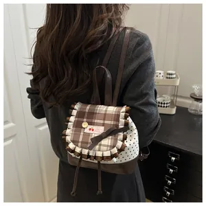 Détail du rabat à carreaux avec écusson cerise et nœud sur ce sac à dos style ballet