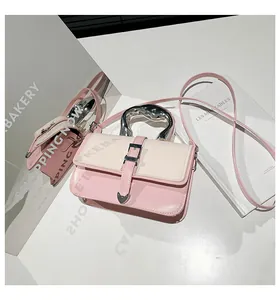 Detail of pink and beige crossbody bag with artistic silver fluid handle and heart strap