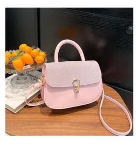 Détail du sac rose avec rabat pailleté, fermoir en U doré et poignée semi-circulaire