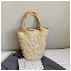 Detail of hand-woven straw bucket bag with herringbone texture on a grey blazer