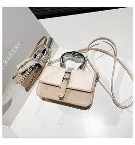 Detail of trendy crossbody bag with unique silver wavy handle and heart-shaped metal buckle