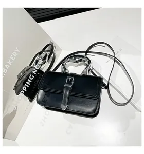 Detail view of black leather handbag with unique silver organic-shaped metal handle