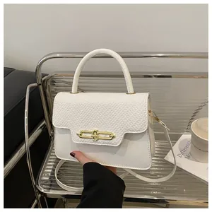 Close-up of white PU leather texture and gold metal buckle on a retro handbag