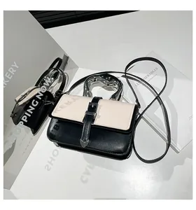 Close-up of contrast crossbody bag featuring creative silver metal handle and beige flap