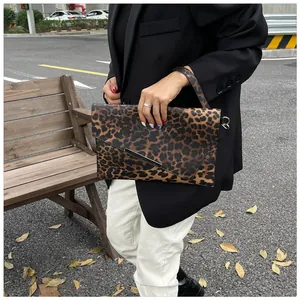 Detail view of stylish leopard print envelope clutch with black metal trim on the flap
