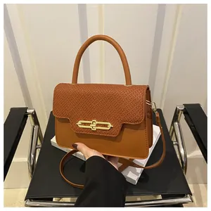 Detail of caramel brown snakeskin texture and gold metal buckle on a mini vintage handbag