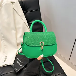 Sac à main vert avec rabat à paillettes et boucle dorée en forme de goutte