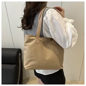 Detail showing the large capacity and glossy nylon material of this stylish tote bag