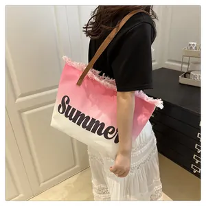 Detail of pink gradient canvas beach tote bag with black Summer print and fringed edges