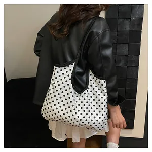 Polka dot tote bag on shoulder showing large capacity and stylish canvas texture