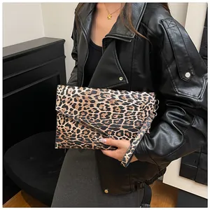 Detail van de luipaardprint envelopclutch met metalen rand en afneembare polsband