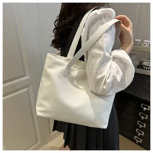 Close-up of a white tote bag with sleek shoulder straps for stylish daily commuting