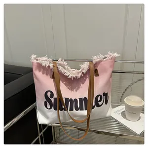 Detail of pink gradient canvas tote bag featuring raw fringe edges and Summer text print