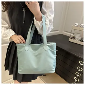 Close-up of a large pale blue tote bag showing the waterproof fabric texture and handles