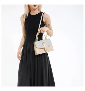 Detail einer beigen Handtasche mit silbernen Pailletten und goldener Hardware am Model