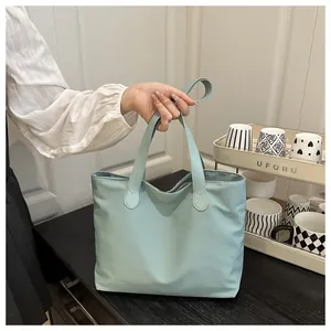 Detailed view of mint blue nylon tote bag with dual handles for daily commuting usage