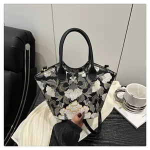 Detailed close-up of intricate gold and white floral embroidery on a black fan-shaped bag