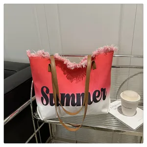 Detail view of large red and white gradient canvas tote with pink tassels and Summer print