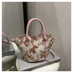 Detail of vintage floral jacquard shoulder bag with unique wavy top and pink round handles