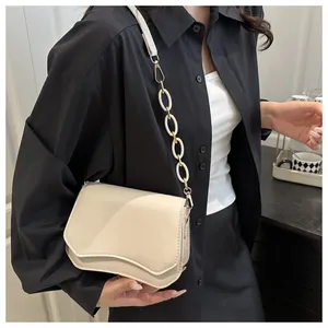 Detail showing wavy flap edge design and large resin ring strap on cream shoulder bag