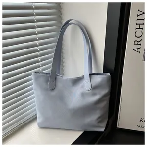 Close-up of a light blue tote bag showing durable straps and high-density fabric texture